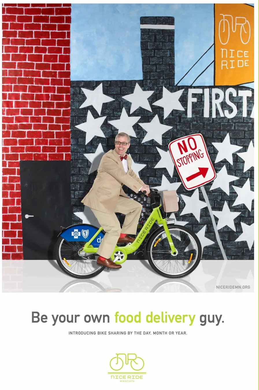 Poster ad featuring rider against Minneapolis street mural with "Be your own food delivery guy" tagline